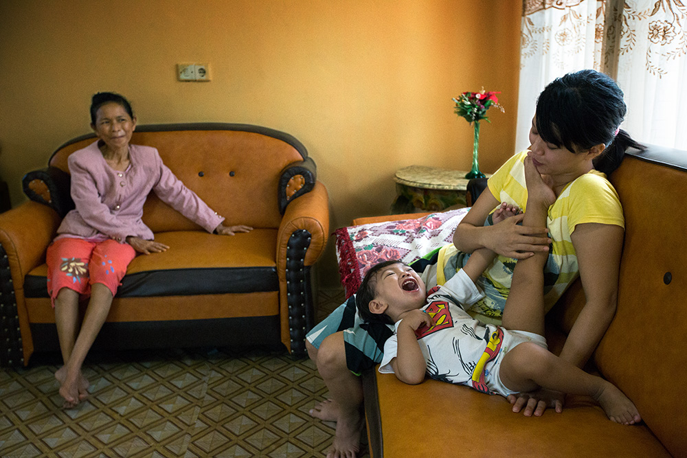Tentena. Rosdika Rampalino (50), whose uncle Kia Wundu was brutally murdered during the conflict, watch her daughter Yulin Mbatono (27) playing with her own son Steve (2). The whole family live together in the town of Tentena.