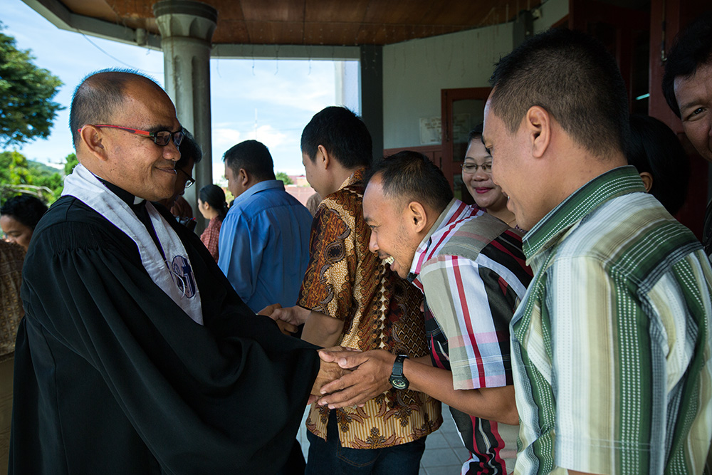 Tentena. A Protestant pastor bless people in front of a church after Sunday mass.
