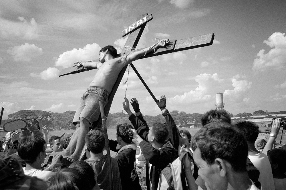Good Friday. People lowers the cross with a cruxified man. This is the celebration of Jesus Christ's death.